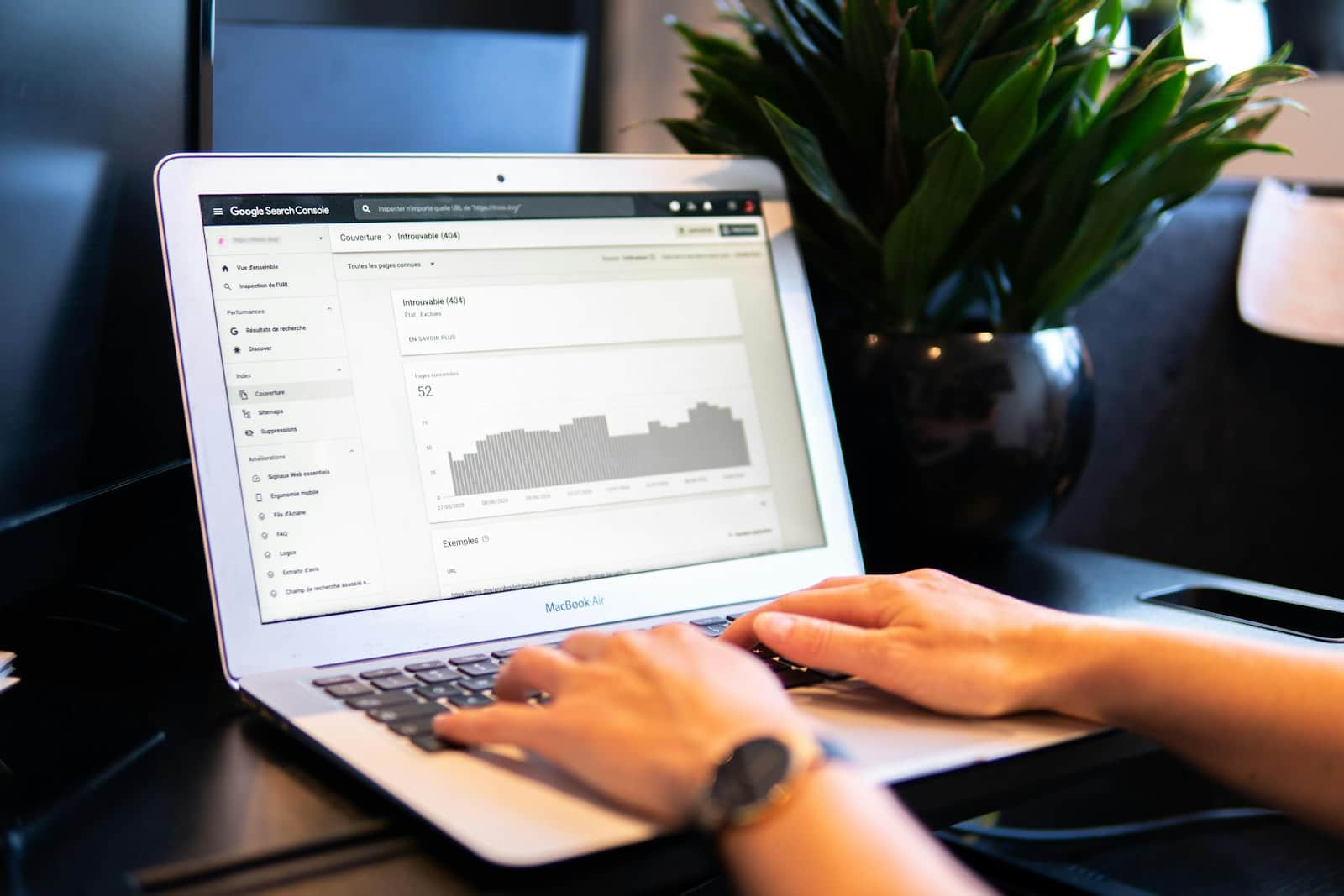 Hands on a laptop showing Google search statistics for a website
